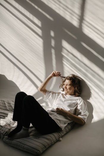 Woman Lying Leaning Against the Wall Smiling · Free Stock Photo
