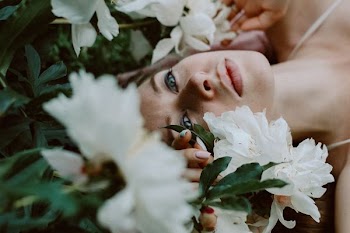 woman lying near petaled flower