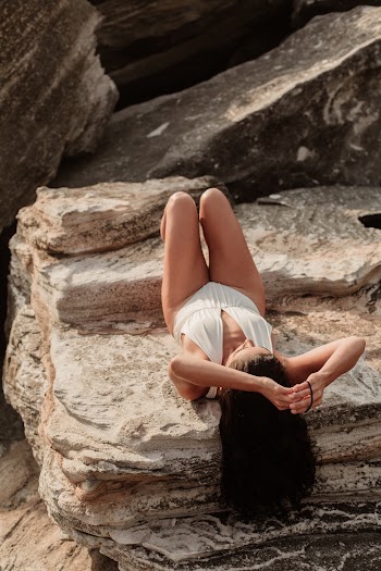 Woman Lying On A Rock With Hands Up