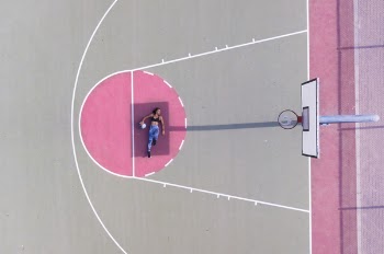 Woman Lying on Basketball Free Throw Line