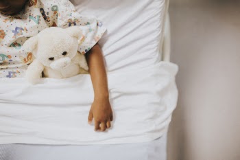 Woman Lying on Bed Holding White Bear Plush Toy