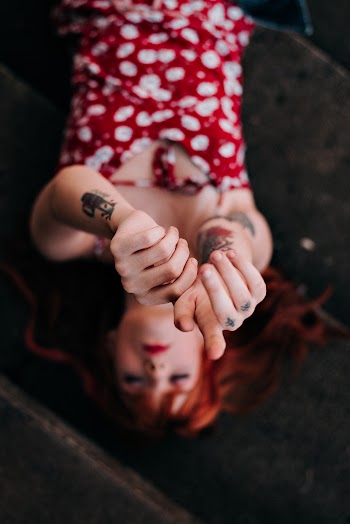 Woman Lying on Black Surface Raising Her Hands Up