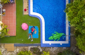 Woman Lying on Blue Mat Beside a Pool