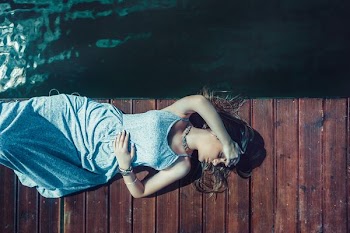 woman lying on brown bridge