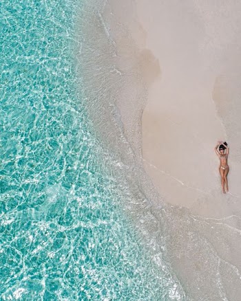 woman lying on brown sand during daytime