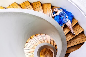 Woman Lying on Brown Wooden Spiral Staircase