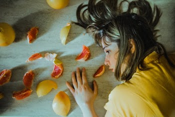 Woman Lying on Floor With Sliced Fruits