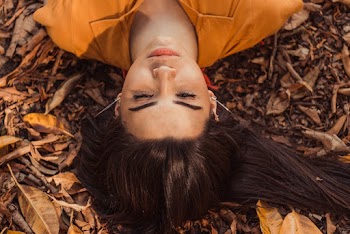 Woman Lying on Ground With Dried Leaves