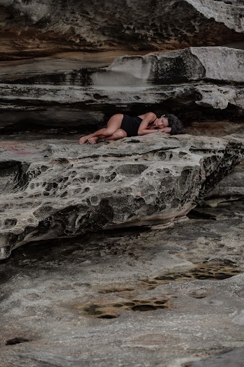 Woman Lying on Rocks
