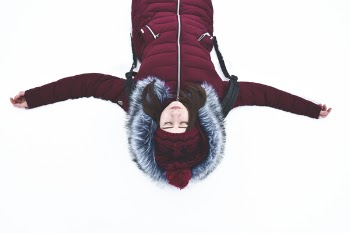 Woman Lying on Snow With Arms Wide Open