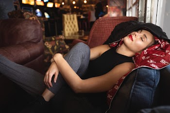 Woman Lying on Sofa Holding Knee