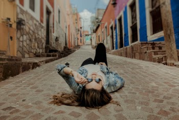 Woman lying on the pavement at an alley