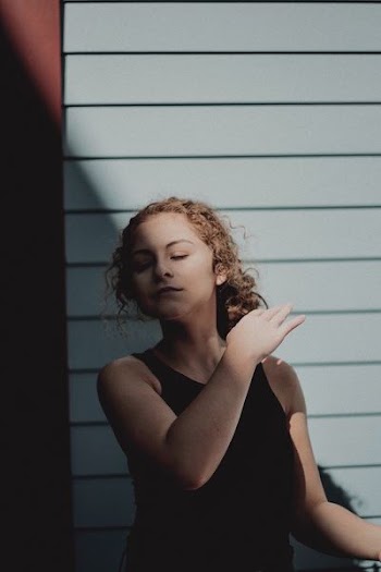 woman meditating near wall