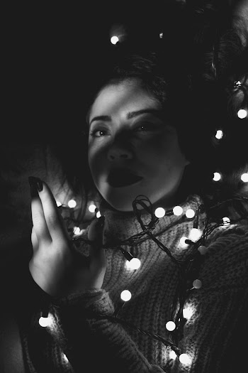 Woman on Bed Holding String Lights