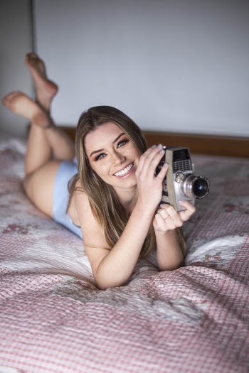 Woman On Bed While Holding Camera