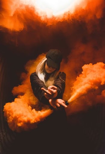 woman on black suit posing with white smoke background