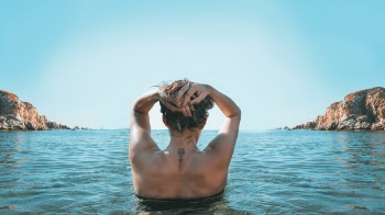 Woman on Holding Her Head While Standing on Body of Water