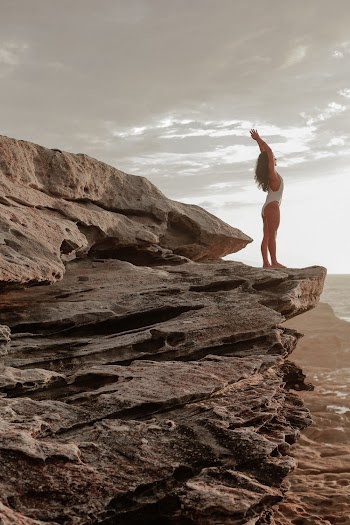 Woman on Rock in White Bathing Suit