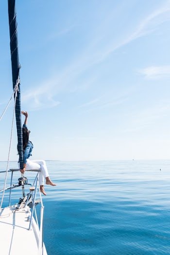 woman on yacht holding a sail at the ocean