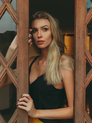 Woman Peeking on Brown Wooden Door