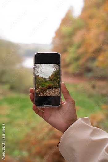 Woman photographing landscape while hiking
