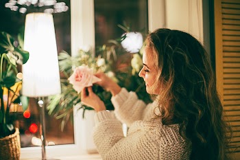 Woman Picking Pink Rose by the Window