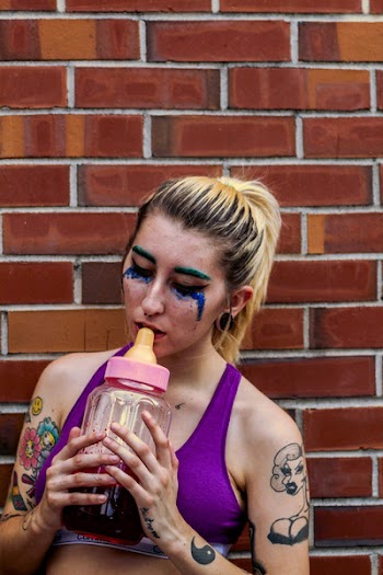 Woman Placing Feeding Bottle on Her Lips