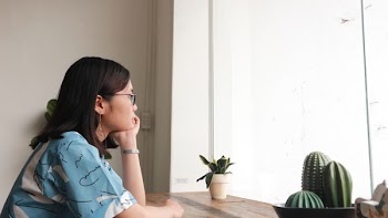 Woman Placing Her Hand on Chin Looking Outside Window