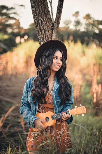 Woman Playing Ukulele Leaning on Tree