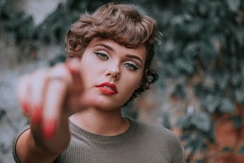 Woman Pointing Towards Her