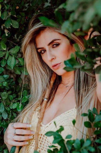Woman Posing By Green Leaves