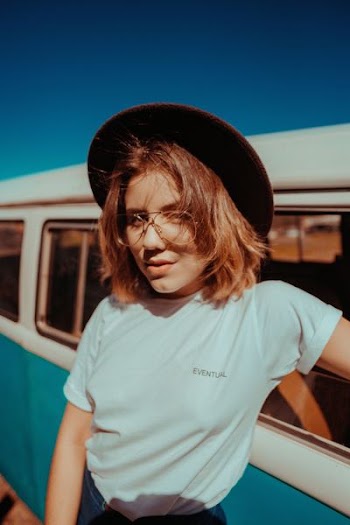 woman posing for photo beside van during daytime