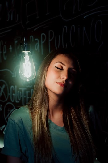 Woman Posing Next to Light Bulb