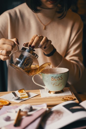 Woman Pouring Tea into Mug