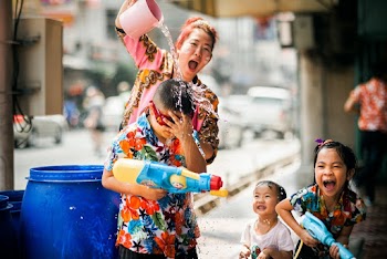 Woman Pouring Water on Child 