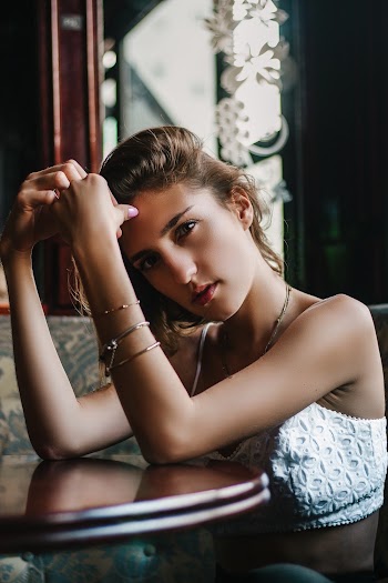 Woman Putting Both Arms on Table While Sitting on Couch