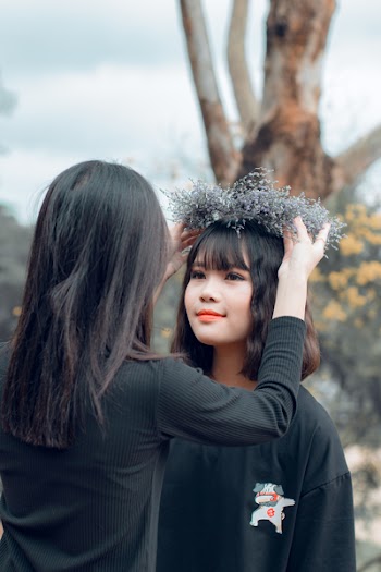 Woman Putting Crown on Women's Head