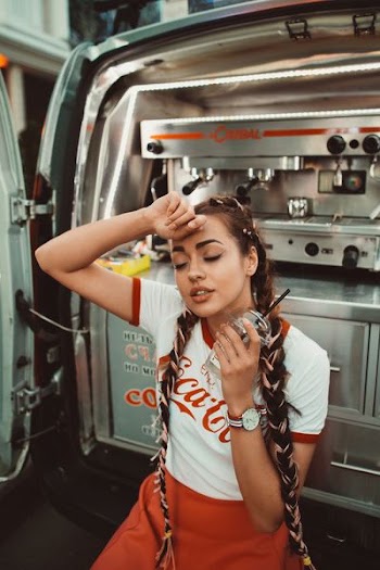 woman putting her hand on her forehead while holding cup