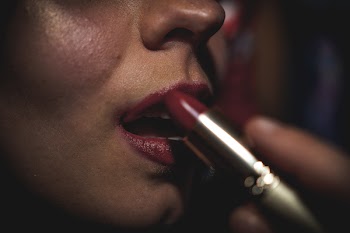 Woman Putting Lipstick on Lips