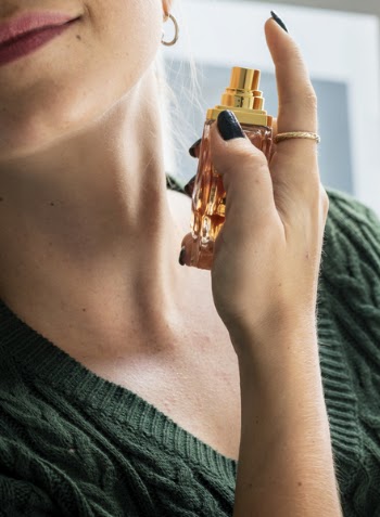 Woman Putting Perfume in Her Neck