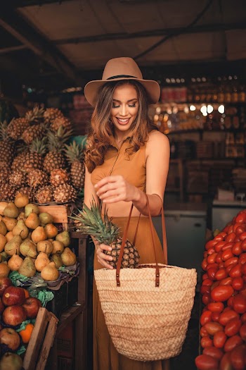 Woman Putting Pineapple in Bag