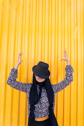 Woman Raising Both Hands While Standing Near Wall