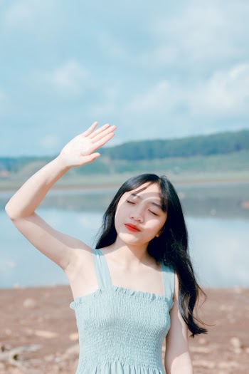 Woman Raising Hand To Cover Sunlight