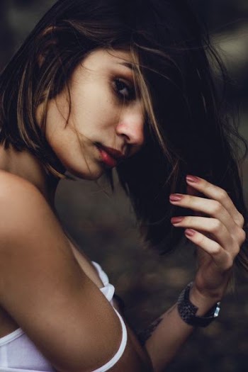 woman raising left arm wearing white shirt