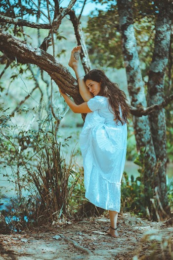 Woman Raising One Leg on Tree Branch