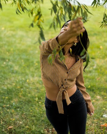 Woman Reaches For Tree Leaves