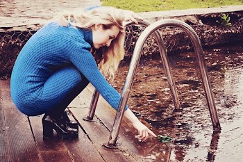 Woman Reaching on Body of Water While Holding Pool Rack