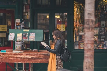 Woman Reading Book Near Store