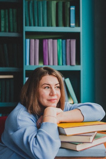 Woman Resting Hands on Pile of Books · Free Stock Photo