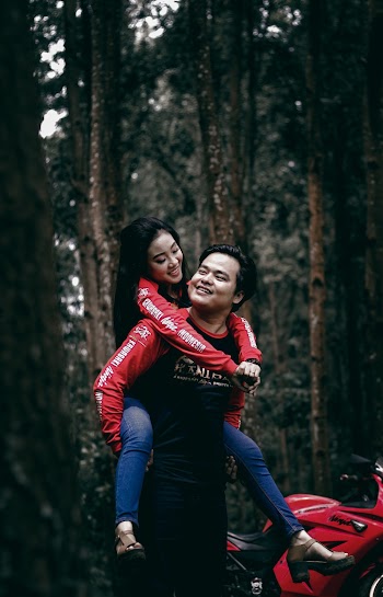 Woman Riding Man's Back Near Motorcycle